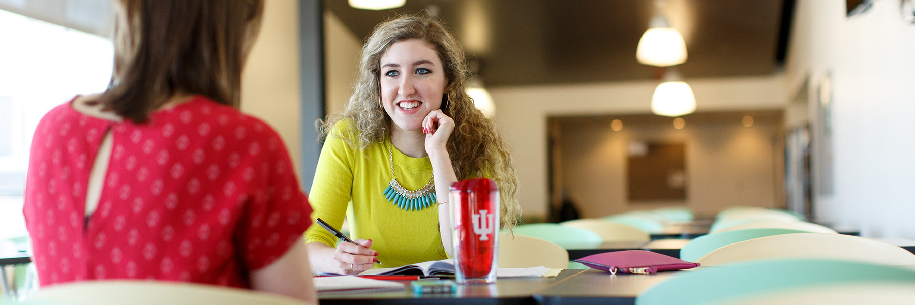 Photo of two women talking in IU Columbus commons. 