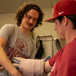 Trainer puts bandage on student
