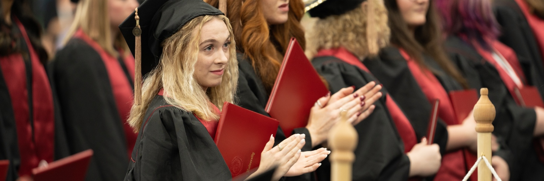 Photo of a female graduate clapping.